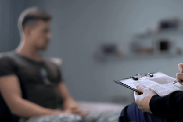 man sits with a doctor as he does a mental health assessment