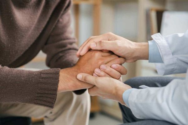 A couple holds hands as they discuss the benefits of mental health treatment at Freeman Recovery Center