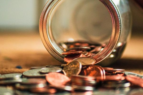 a jar lying on it's side with change coming out representing mental health treatment