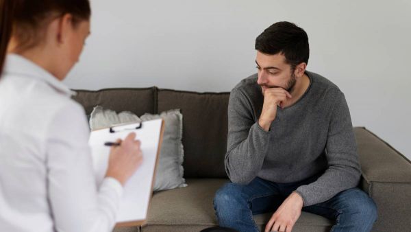 Man discussing trauma symptoms with therapist during counseling in Nashville.