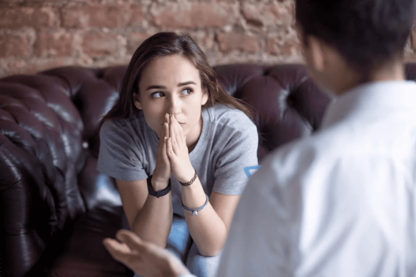 girl sitting in therapist office discussing mental health treatment options