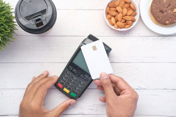 A person holding a credit card to pay for mental health treatment therapy