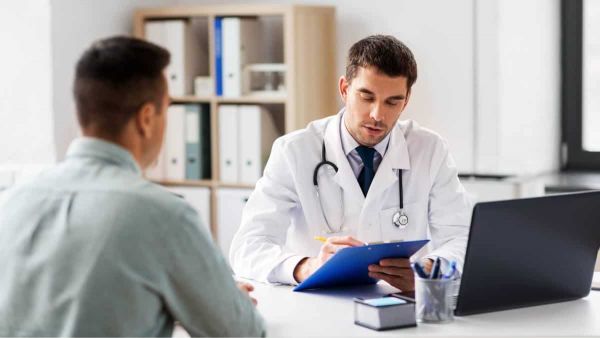 Man navigating the process of how to find a PCP by asking questions to a healthcare professional in person.