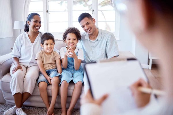 a family sits together smiling as they work together to heal from mental health issues