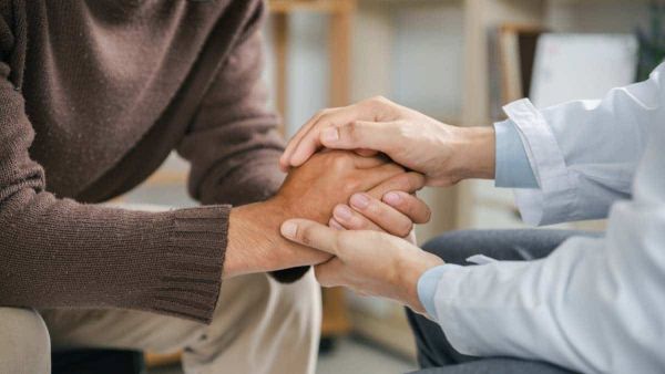 A couple holds hands as they discuss the benefits of mental health treatment at Freeman Recovery Center