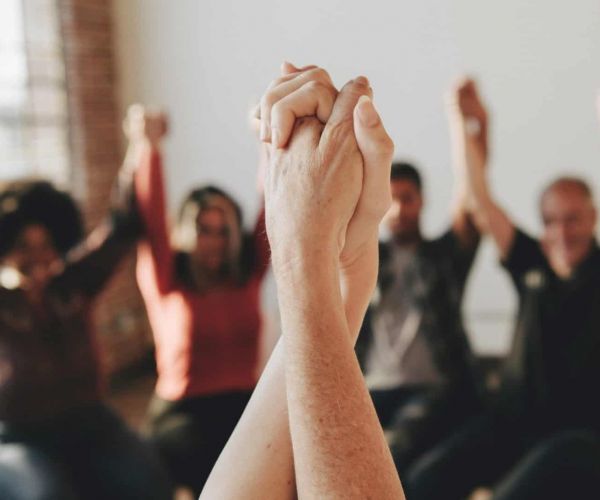 a group of people holding hands as they heal from mental health issues