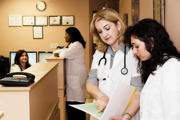 nurses stand together reviewing charts as they treatment mental health issues