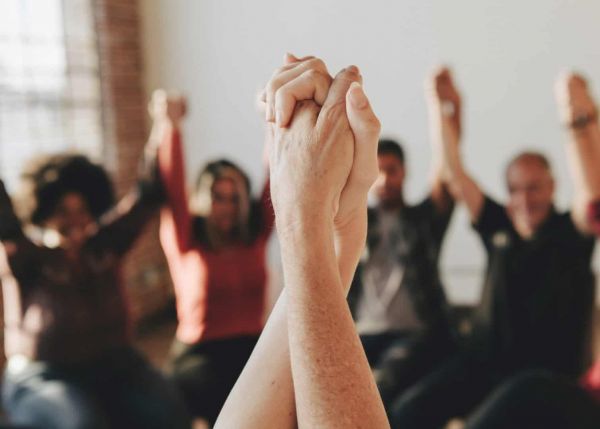 a group of people holding hands as they heal from mental health issues