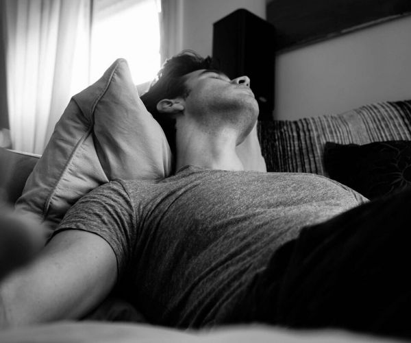 man lays in bed having trouble sleeping as he deals with sleep disorders