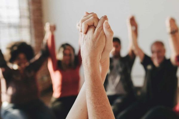 a group of people holding hands as they heal from mental health issues