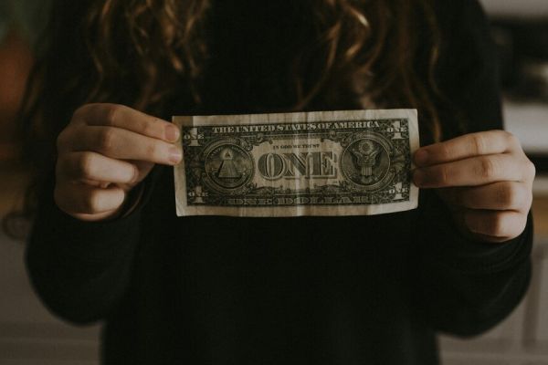 a woman holding a dollar representing the cost of depression treatment