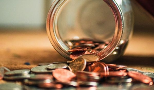 a jar lying on it's side with change coming out representing mental health treatment