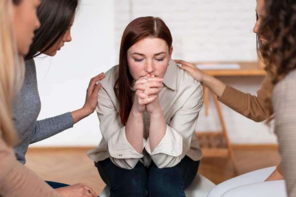 A group of close friends offering compassionate support to a friend facing mental health challenges, a powerful way of how to help someone struggling with mental health.