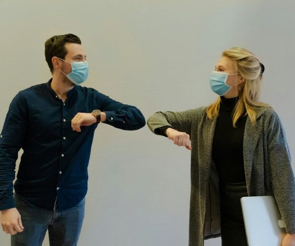 two people touch elbows representing chronic treatment management