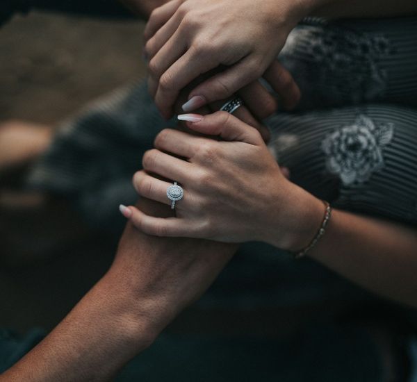 Two people holding hands as they support each other with mental health struggles