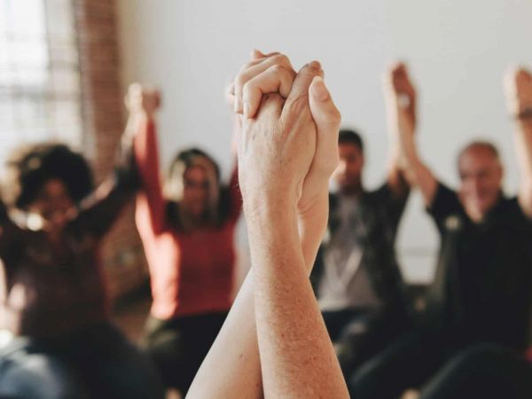 a group of people holding hands as they heal from mental health issues