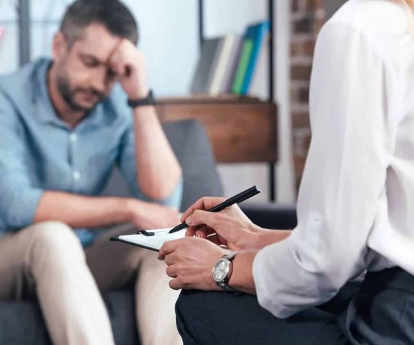 man sits with a doctor as he does a mental health assessment