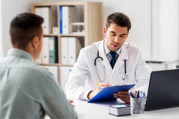 Man navigating the process of how to find a PCP by asking questions to a healthcare professional in person.