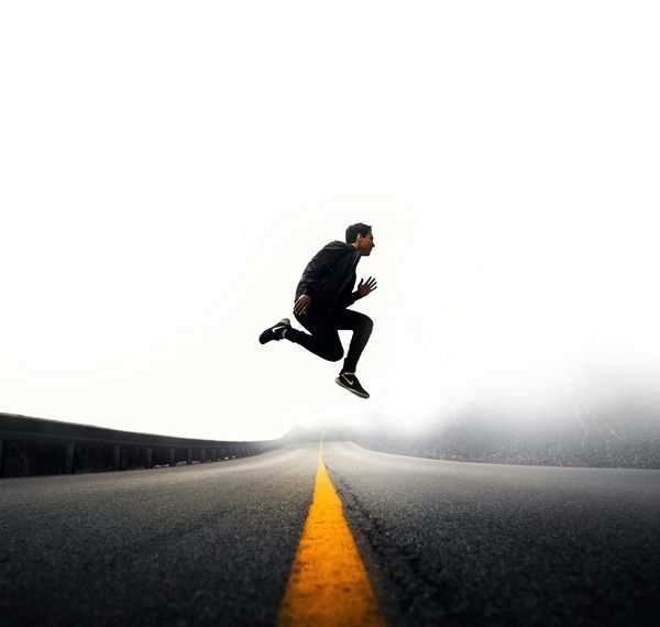 man jumping in the air across a road celebrating success over mental help
