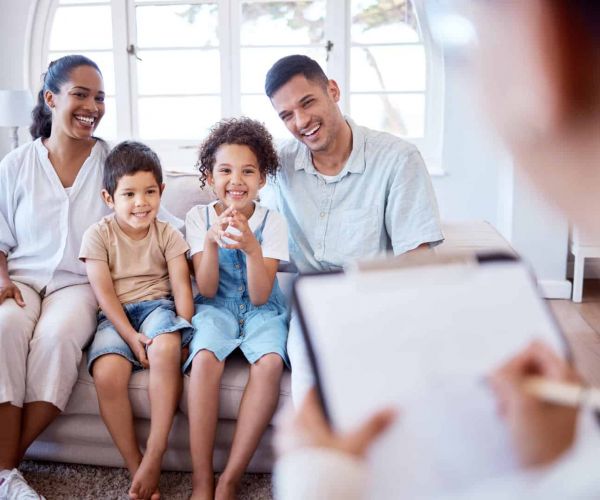 a family sits together smiling as they work together to heal from mental health issues