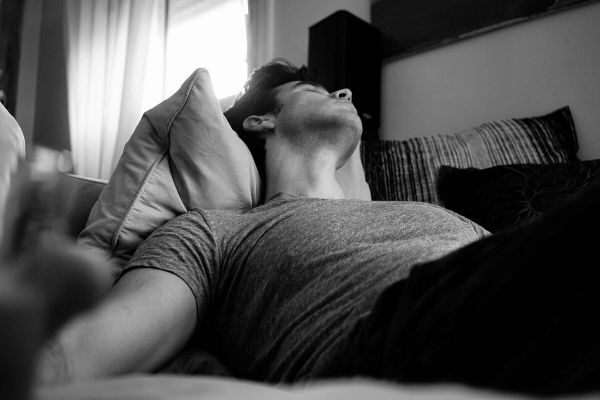man lays in bed having trouble sleeping as he deals with sleep disorders