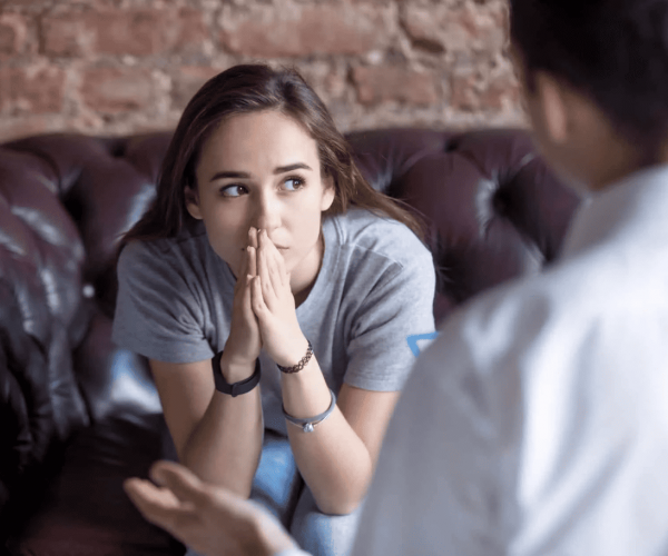girl sitting in therapist office discussing mental health treatment options