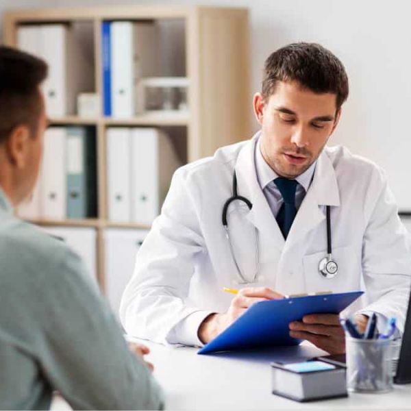 Man navigating the process of how to find a PCP by asking questions to a healthcare professional in person.