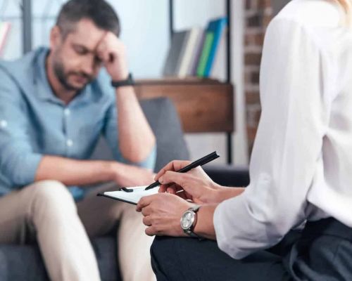 man sits with a doctor as he does a mental health assessment