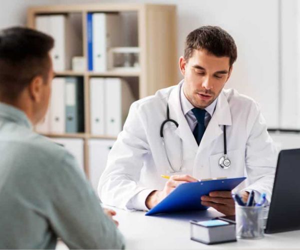 Man navigating the process of how to find a PCP by asking questions to a healthcare professional in person.