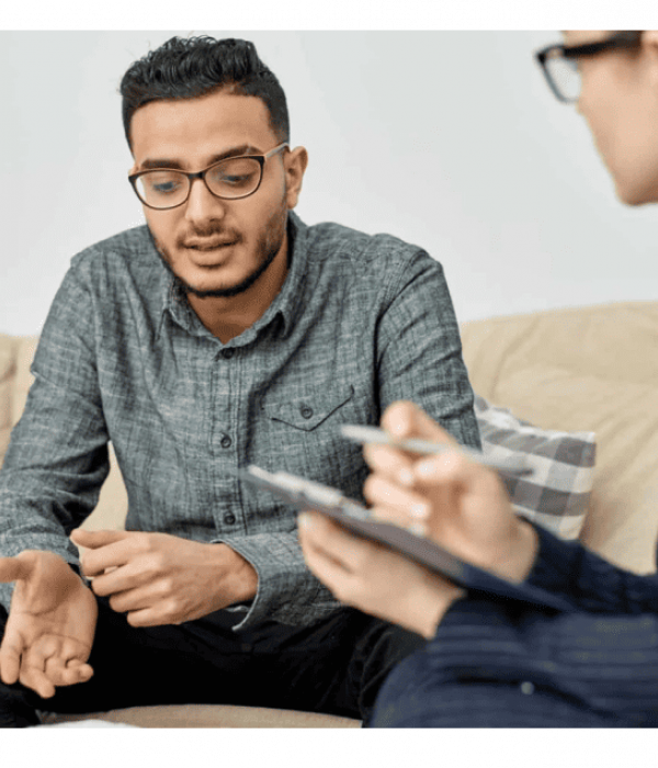 man sitting in therapist office discussing mental health treatment options