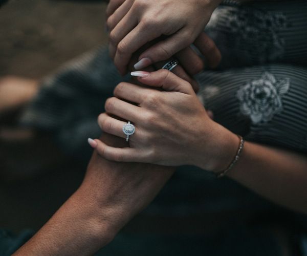 Two people holding hands as they support each other with mental health struggles